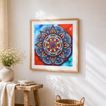 Jewel tone red and blue mandala cross stitch artwork displayed on wall as home decor