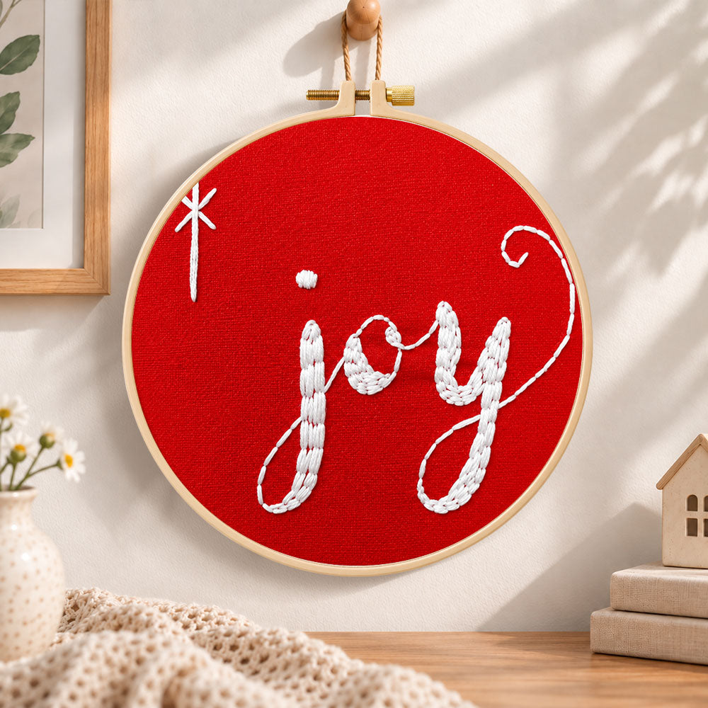 Joy christmas script embroidery hoop wall art displayed as warm and cozy handmade home decor