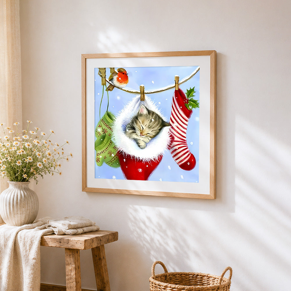 Kitten sleeping in christmas stocking cross stitch artwork displayed on wall as home decor