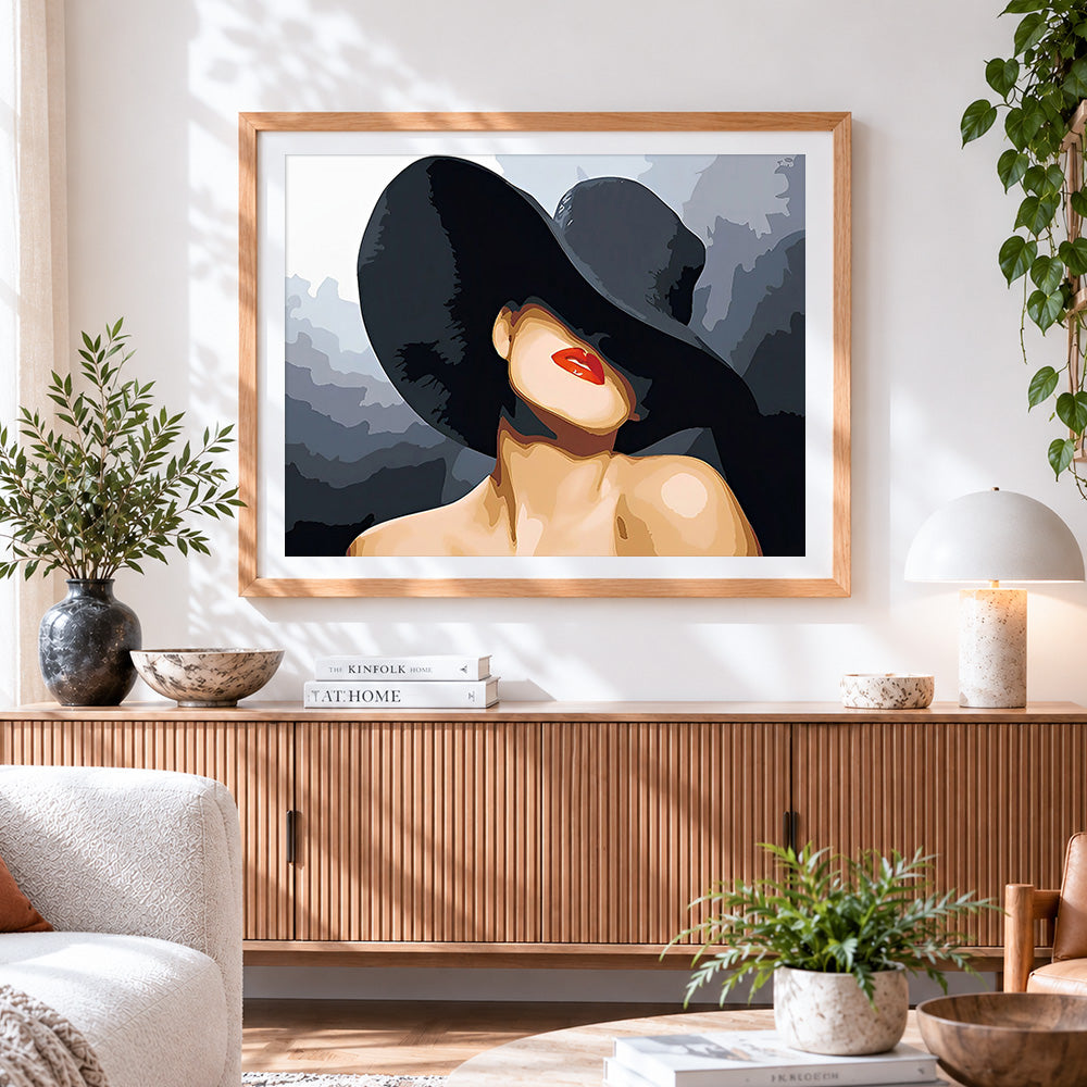 Finished lady in a black hat with red lips cross stitch artwork displayed