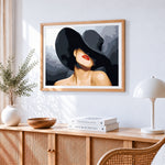 Lady in a black hat with red lips cross stitch artwork displayed on wall as home decor