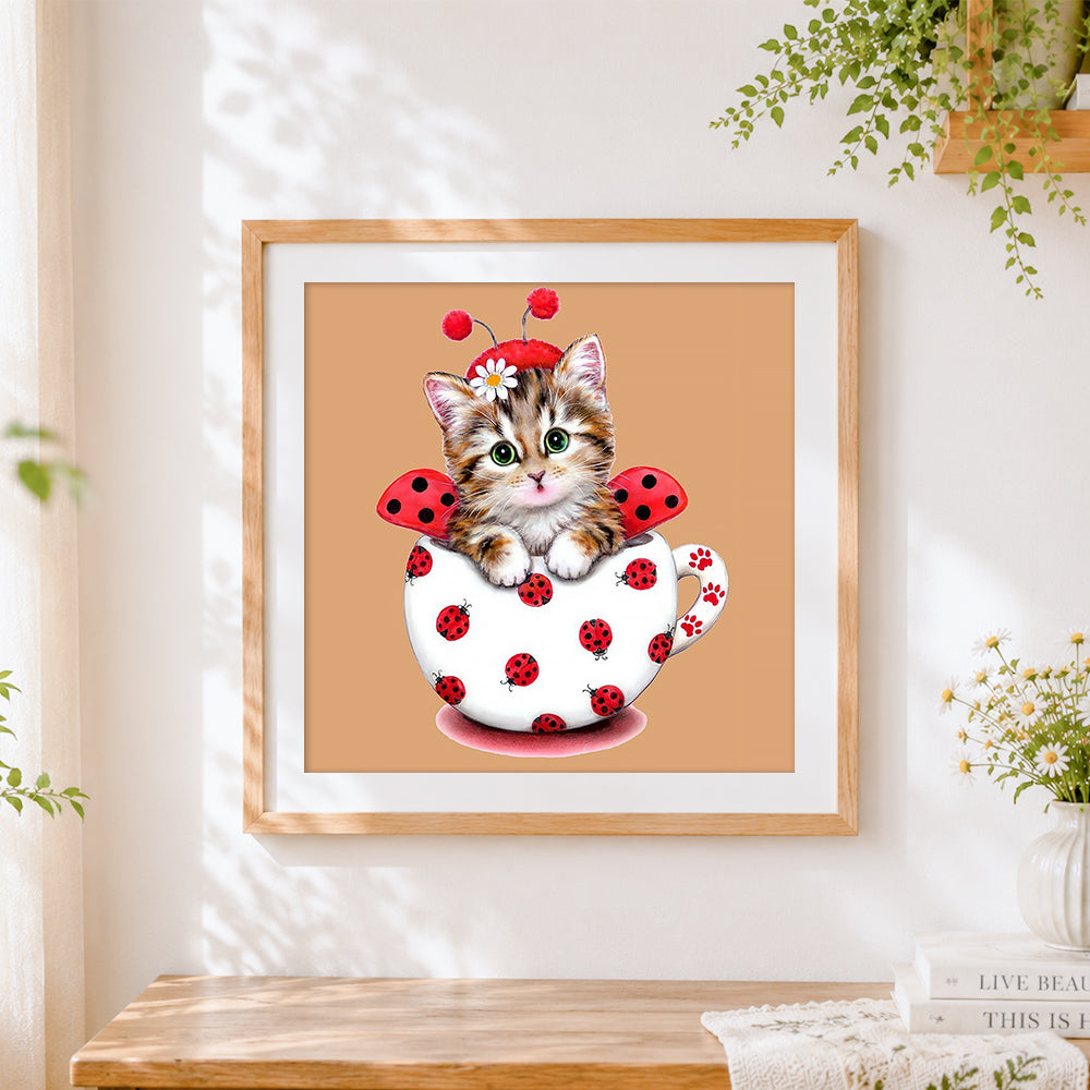 Finished ladybird cat in teacup cross stitch artwork displayed