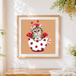 Finished ladybird cat in teacup cross stitch artwork displayed