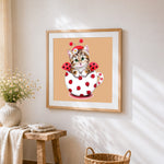 Ladybird cat in teacup cross stitch artwork displayed on wall as home decor