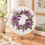 Lavender purple wreath and letter j embroidery kit finished hoop displayed on a wooden stand as cosy tabletop decor