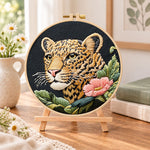 Leopard and pink wildflower embroidery kit finished hoop displayed on a wooden stand as cosy tabletop decor