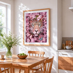Leopard surrounded by pink blossoms cross stitch artwork displayed on wall as home decor