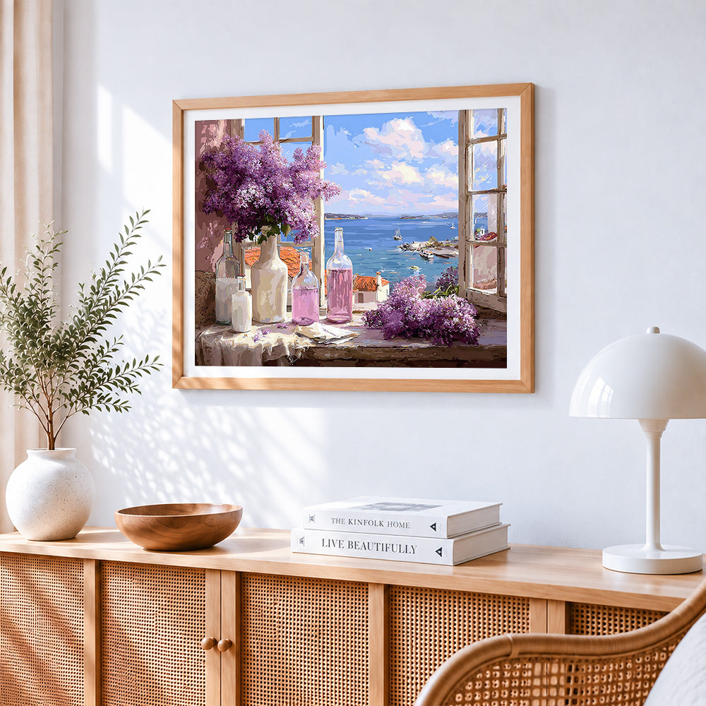 Lilacs in window with sea view cross stitch artwork displayed on wall as home decor