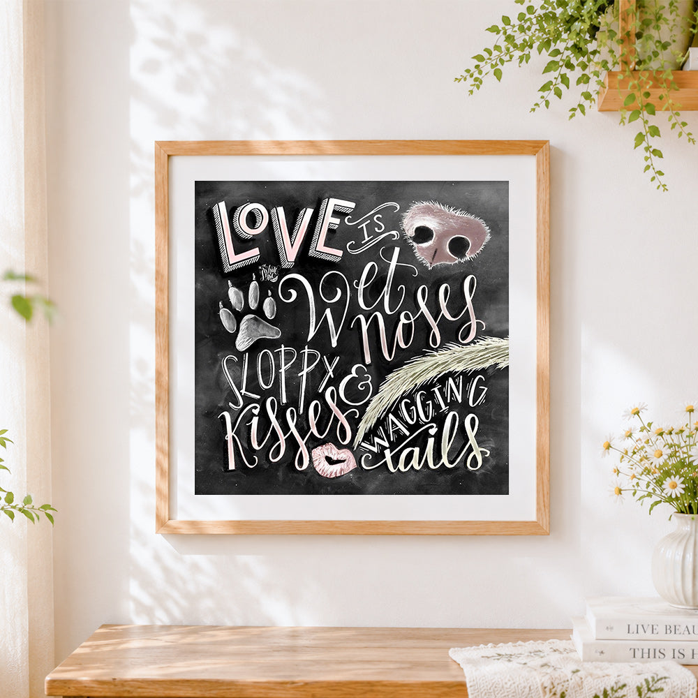 Finished love is wet noses and sloppy kisses cross stitch artwork displayed