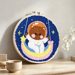Lovely space bear on a moon swing punch needle artwork displayed on a table