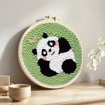 Lying panda punch needle artwork displayed on a table