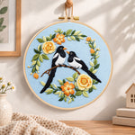 Magpie pair with yellow flowers embroidery hoop wall art displayed as warm and cosy handmade home decor