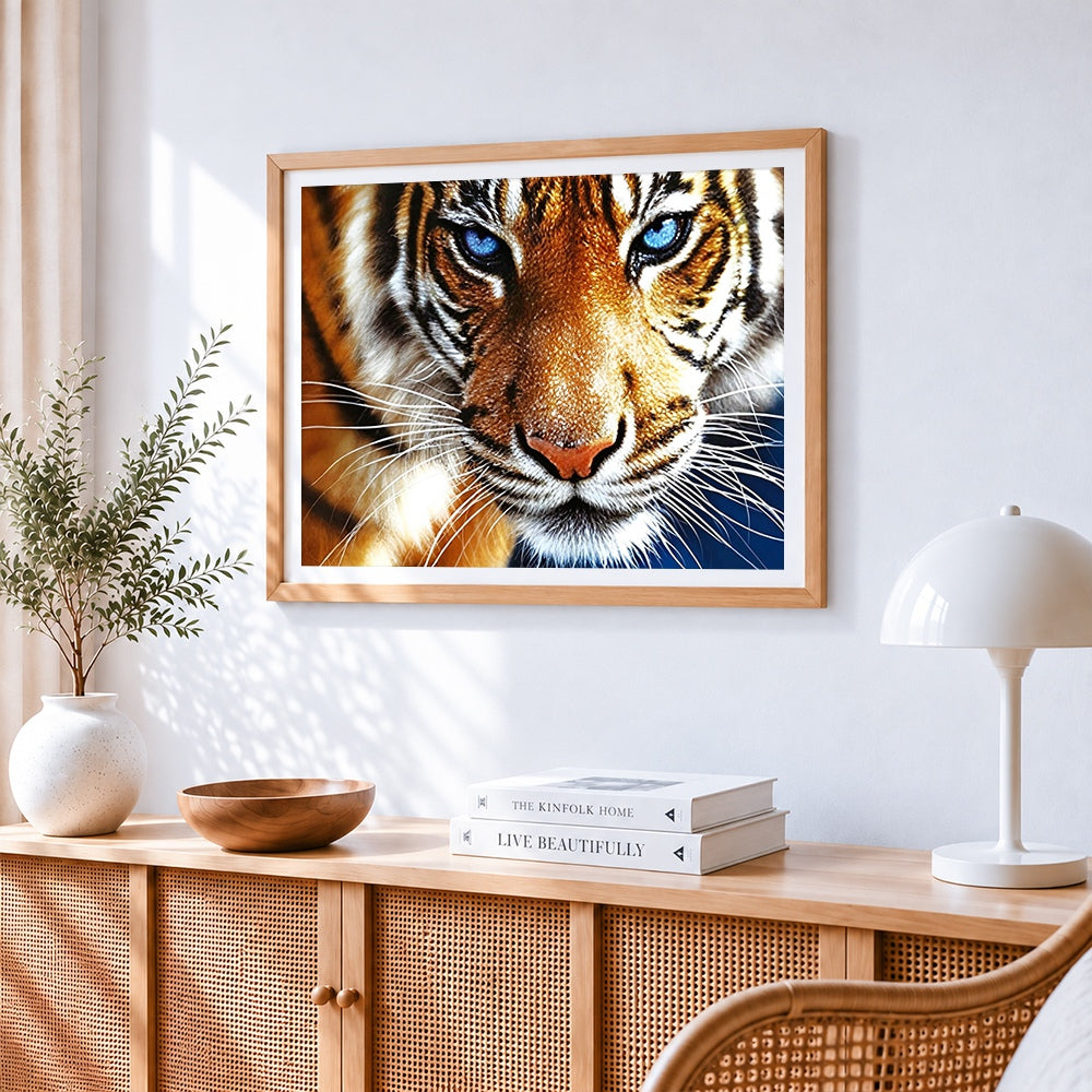 Majestic bengal tiger with blue eyes cross stitch artwork displayed on wall as home decor