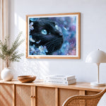 Majestic black cat with blue eyes cross stitch artwork displayed on wall as home decor