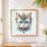 Finished majestic blue-eyed cat with gold jewellery cross stitch artwork displayed