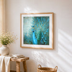 Majestic blue peacock cross stitch artwork displayed on wall as home decor