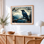 Majestic raven in a mountain landscape cross stitch artwork displayed on wall as home decor