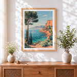 Finished mediterranean cliffside and sailboat cross stitch artwork displayed