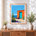 Finished mexican orange casita and cactus cross stitch artwork displayed