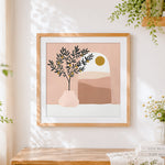 Finished minimalist olive tree and sun cross stitch artwork displayed