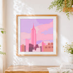 Finished minimalist pink city skyline cross stitch artwork displayed