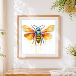 Finished minimalist watercolour bee with drip effect cross stitch artwork displayed