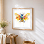 Minimalist watercolour bee with drip effect cross stitch artwork displayed on wall as home decor