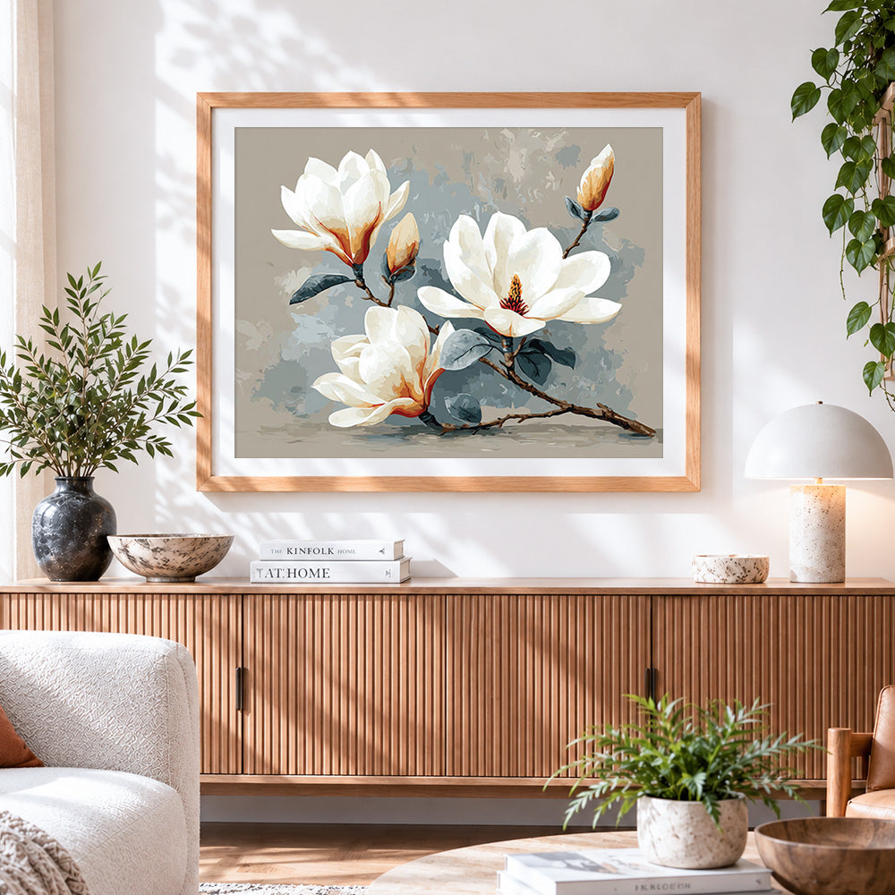 Finished minimalist white magnolia branch cross stitch artwork displayed