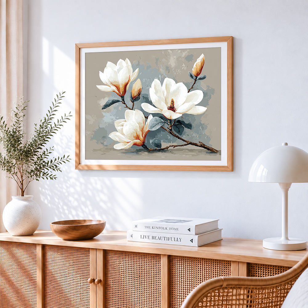 Minimalist white magnolia branch cross stitch artwork displayed on wall as home decor