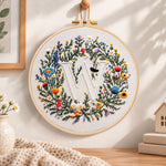 Mixed floral wreath and letter w embroidery hoop wall art displayed as warm and cosy handmade home decor