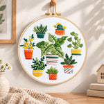 Mixed mini potted greenery embroidery hoop wall art displayed as warm and cosy handmade home decor