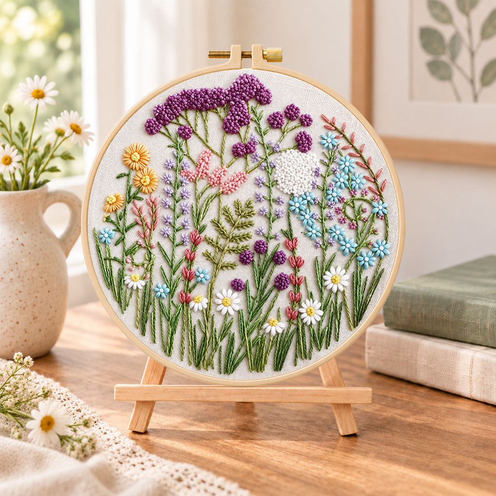 Mixed wildflower field embroidery kit finished hoop displayed on a wooden stand as cosy tabletop decor