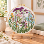 Mixed wildflower field embroidery kit finished hoop displayed on a wooden stand as cosy tabletop decor