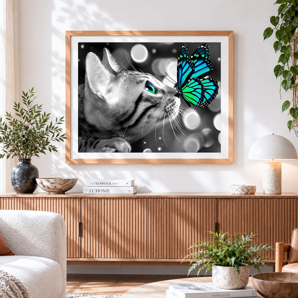 Finished monochrome cat and green butterfly cross stitch artwork displayed