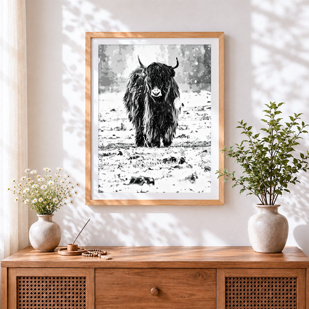 Finished monochrome highland cow in snow cross stitch artwork displayed