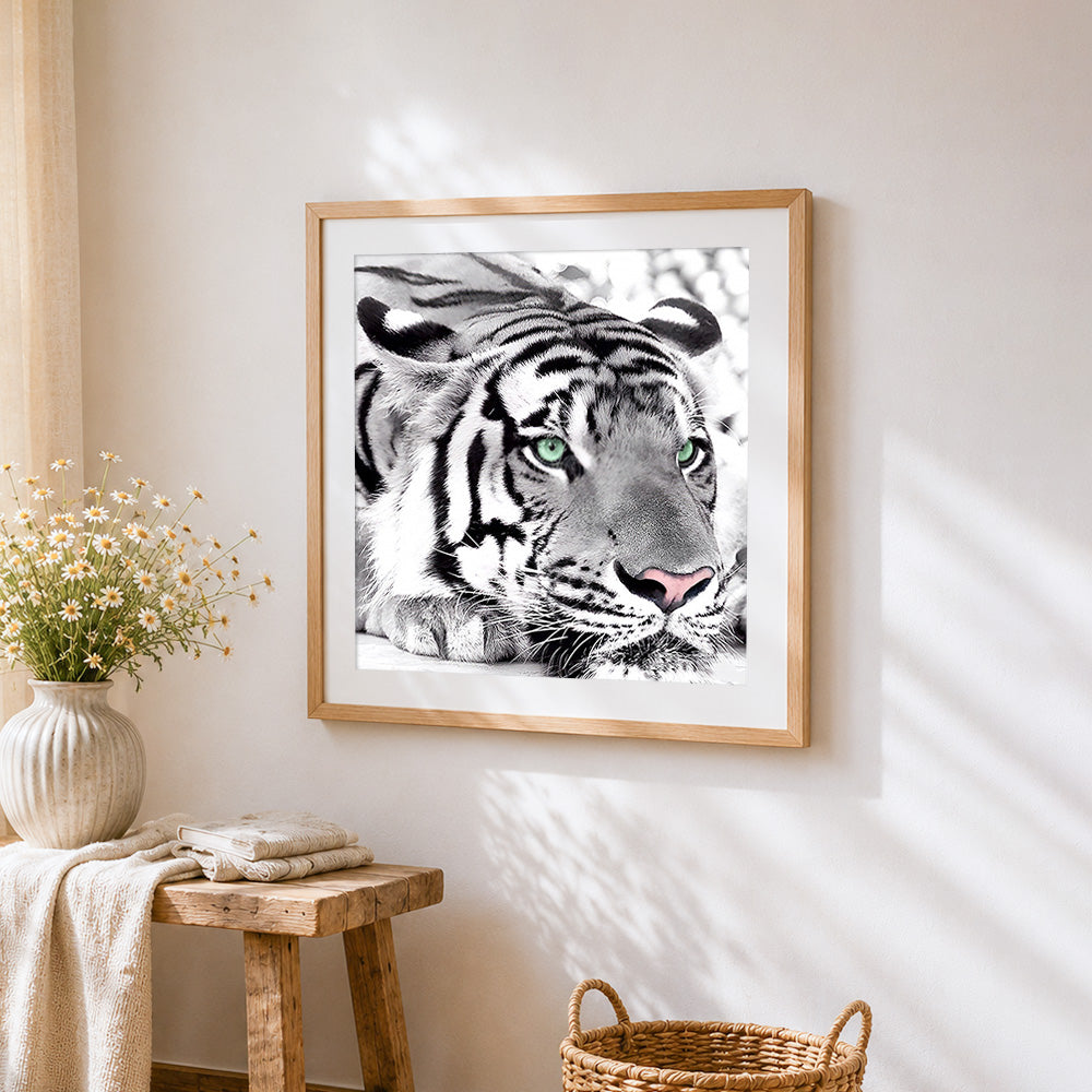 Monochrome tiger with green eyes cross stitch artwork displayed on wall as home decor