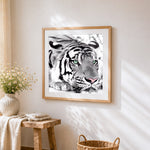 Monochrome tiger with green eyes cross stitch artwork displayed on wall as home decor