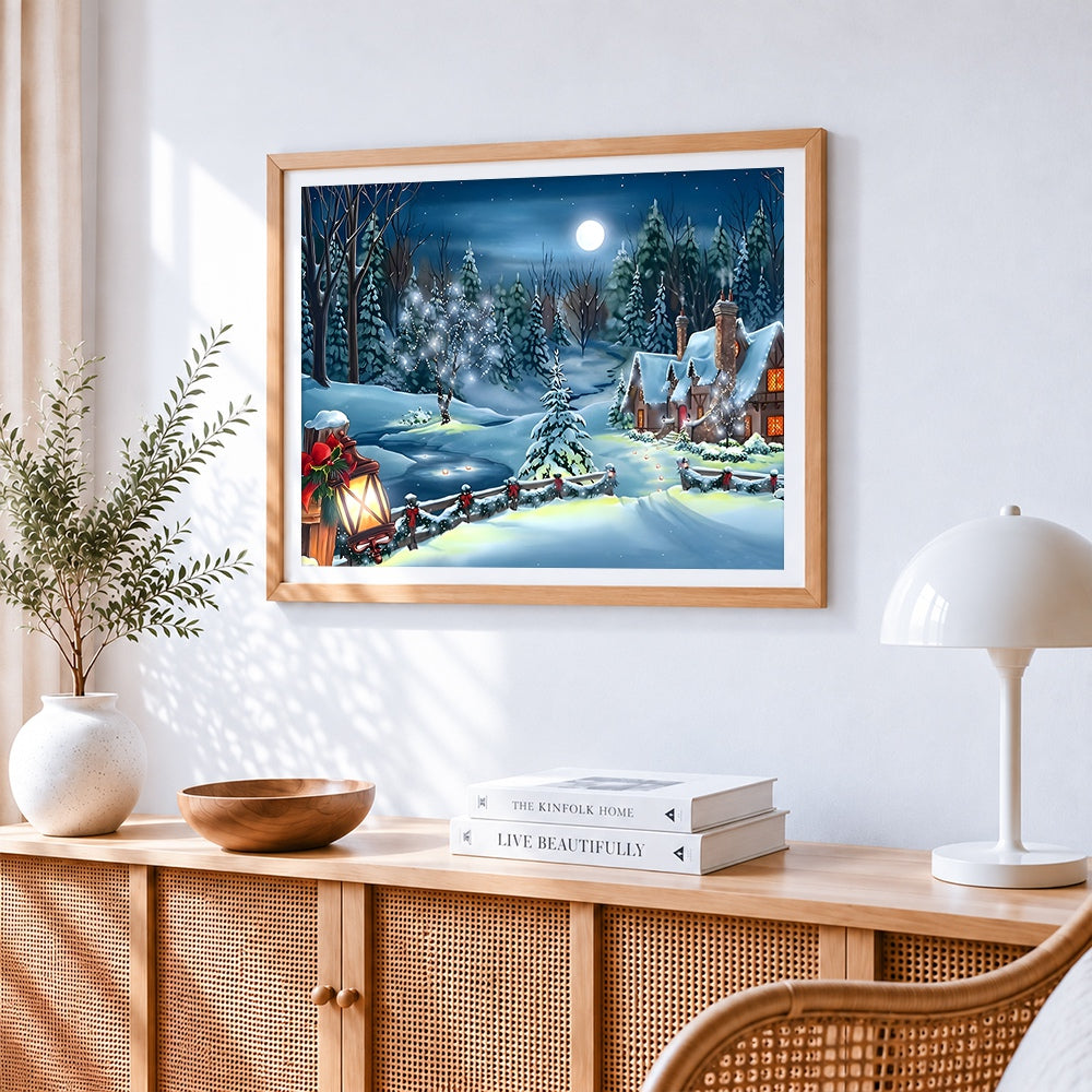 Moonlit snowy cottage with festive lanterns cross stitch artwork displayed on wall as home decor