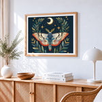Moth with crescent moon and leaves cross stitch artwork displayed on wall as home decor
