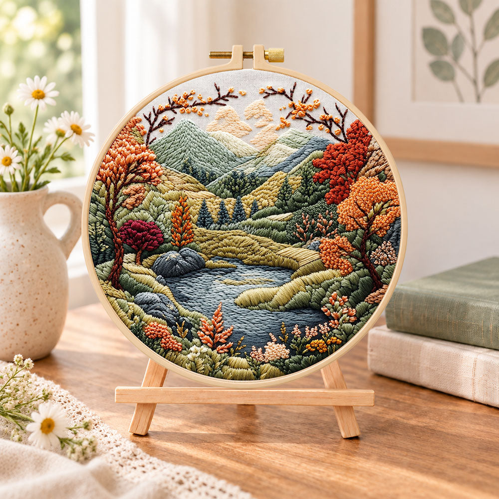 Mountain lake autumn landscape embroidery kit finished hoop displayed on a wooden stand as cozy tabletop decor
