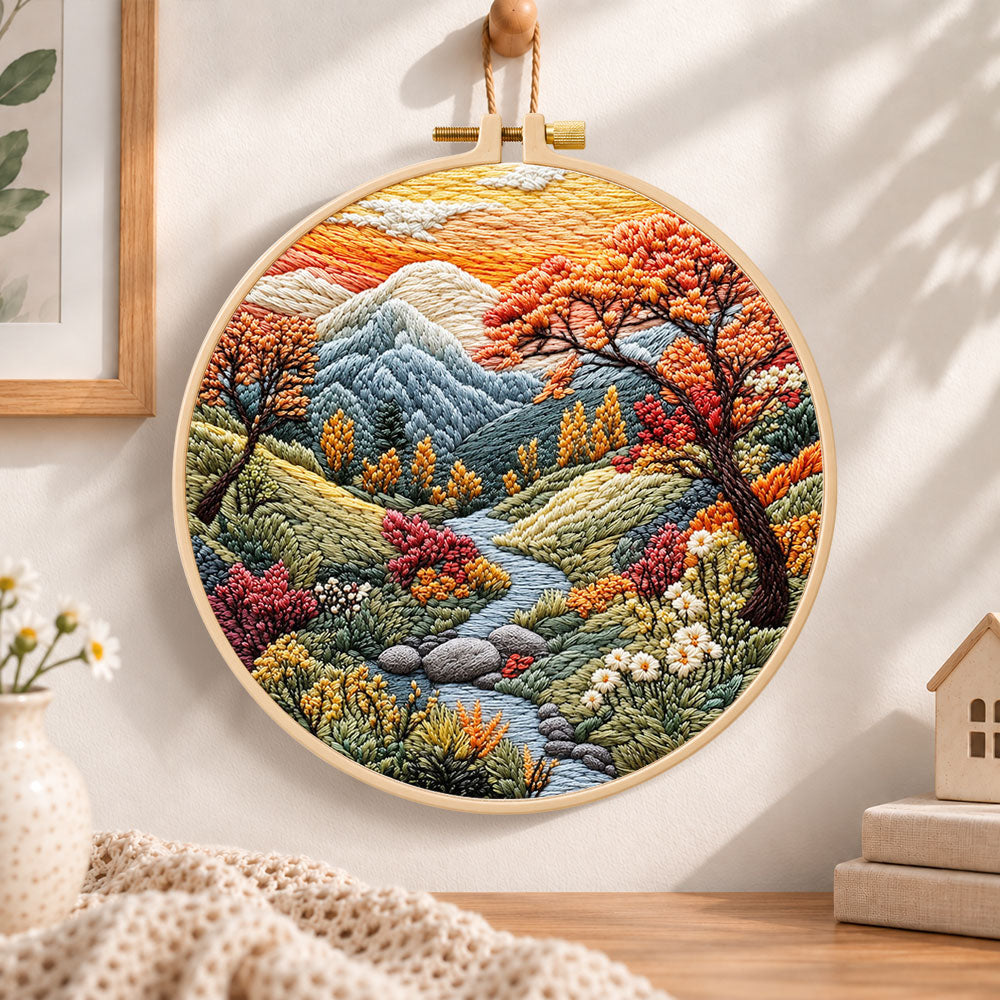 Mountain stream at sunset embroidery hoop wall art displayed as warm and cozy handmade home decor