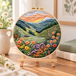 Mountain wildflower valley embroidery kit finished hoop displayed on a wooden stand as cozy tabletop decor