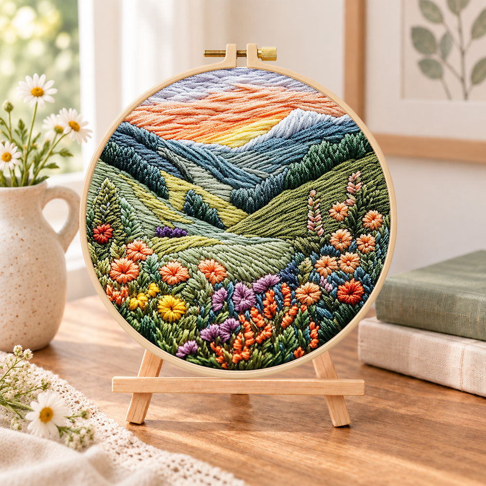 Mountain wildflower valley embroidery kit finished hoop displayed on a wooden stand as cozy tabletop decor
