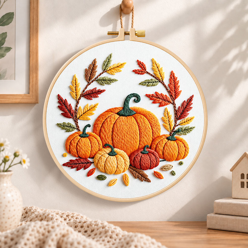 Multiple pumpkins with autumn leaves embroidery hoop wall art displayed as warm and cosy handmade home decor