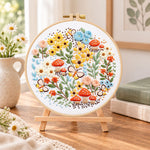 Mushroom and butterfly garden embroidery kit finished hoop displayed on a wooden stand as cosy tabletop decor