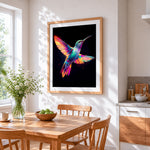 Neon hummingbird in flight cross stitch artwork displayed on wall as home decor