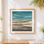 Finished ocean and shore cross stitch artwork displayed