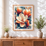 Finished orange and white magnolias cross stitch artwork displayed