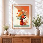Finished orange flowers in a red vase cross stitch artwork displayed