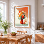 Orange flowers in a red vase cross stitch artwork displayed on wall as home decor